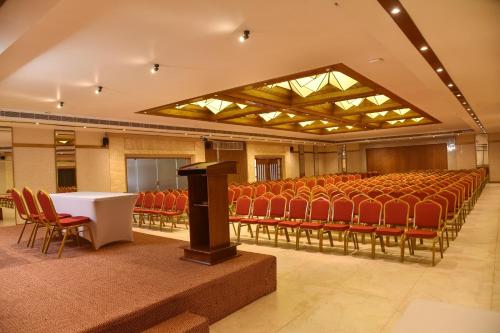 a lecture hall with red chairs and a podium at THE PEARL VIEW HOTEL in Mulappilangād