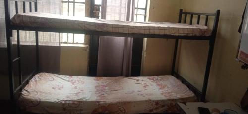 two bunk beds in a room with a bed on it at Kioneki hostels in Nairobi