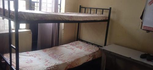 two bunk beds in a room with a window at Kioneki hostels in Nairobi