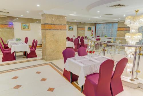 a banquet hall with tables and purple chairs at Hayah Al Waha Hotel in Al Madinah