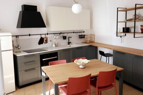 eine Küche mit einem Holztisch und roten Stühlen in der Unterkunft La Casa nel Borgo in Montecastrilli