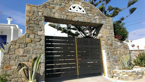 a gate in a stone wall with a door at Mykonos Double Luxury Mini Suites-With External Hot spa Adults only in Ano Mera