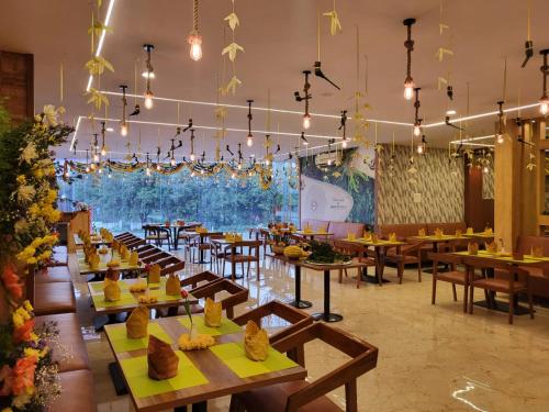 un restaurante con mesas de madera, sillas y luces en Hotel Plaza Airport Zone en Shamshabad