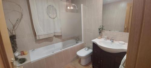 a bathroom with a sink and a toilet and a tub at Casa Rural Rincones de Albares in Albares