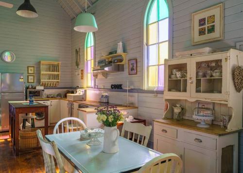 a kitchen with a table with a vase of flowers on it at St Aidan's - Converted Church in Mudgee