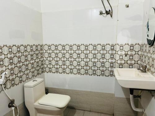 a bathroom with a toilet and a sink at Hotel Plaza Airport Zone in Shamshabad