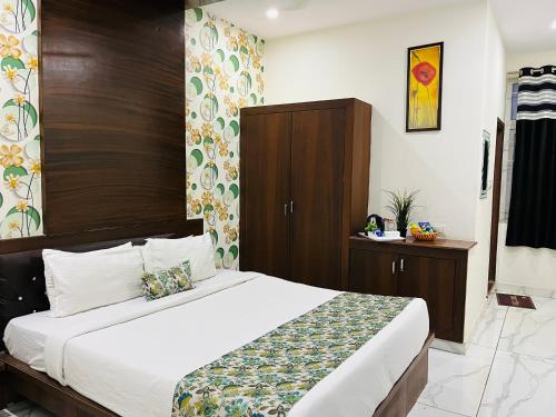 a bedroom with a large bed with a wooden headboard at Hotel Plaza Hyderabad Airport Zone in Shamshabad