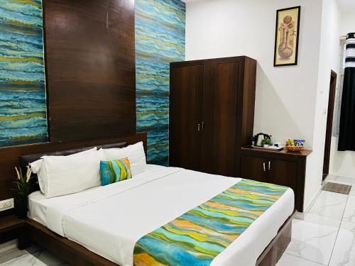 a bedroom with a bed with a painting on the wall at Hotel Plaza Hyderabad Airport Zone in Shamshabad