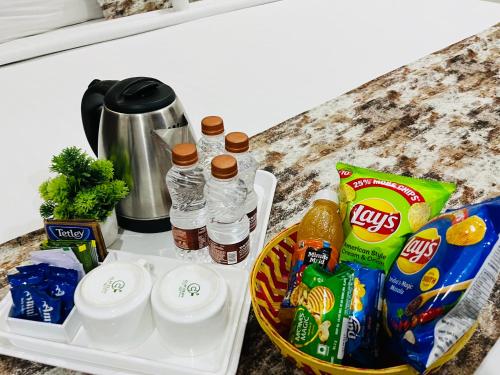 a tray with drinks and snacks on a counter at Hotel Plaza Hyderabad Airport Zone in Shamshabad