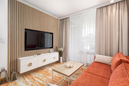 a living room with a couch and a tv at Sun & Beach Apartments Bel Mare with Parking by Renters in Międzyzdroje