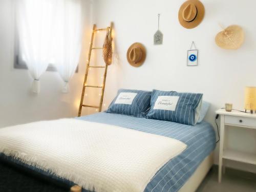 1 dormitorio con 1 cama con sábanas azules y blancas en Roberta's Apt Flea Market/Patio/ By the beach, en Tel Aviv