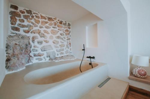 a bathroom with a stone wall and a bath tub at Hotel Unique-Boutique Class - Adults Only in Fethiye