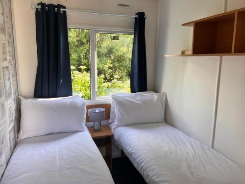 two beds in a room with a window at Cornish coastal retreats- 74 newquay view in Porth