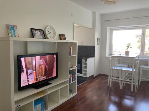ein Wohnzimmer mit einem TV und einem Esszimmer in der Unterkunft Scenic apartment close to nature in Helsinki in Helsinki