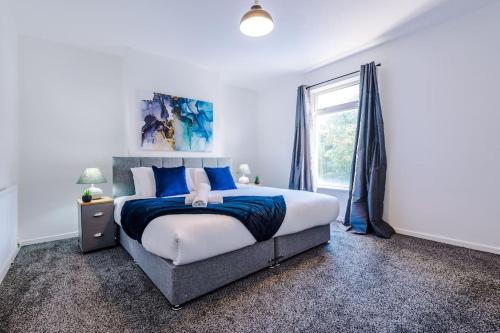 マンチェスターにあるCosy & Bright 2 BR House MCRのベッドルーム1室(青い枕のベッド1台、窓付)