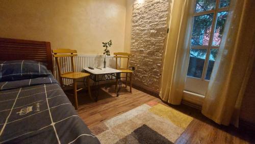 um quarto com uma mesa, uma cama e uma janela em Vila Zlatibor em Zlatibor