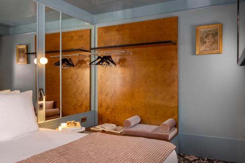 a bedroom with a bed and a mirror at Hôtel La Conversation in Paris