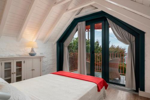 a bedroom with a bed and a large window at Villa Do Mar in Arco da Calheta