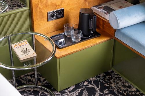 a small table with a coffee maker and glasses on it at Hôtel La Conversation in Paris