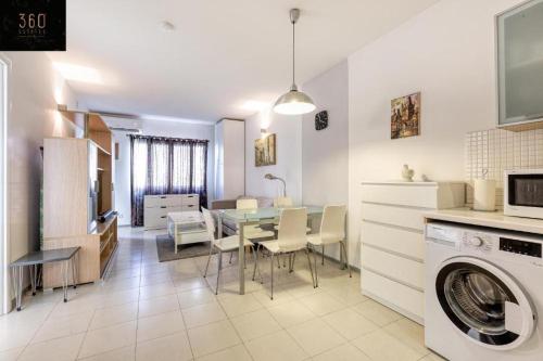 eine Küche und ein Esszimmer mit einem Tisch und einer Waschmaschine in der Unterkunft Cozy 1 Bedroom Oasis in the Heart of St. Julians by 360 Estates in St Julian's