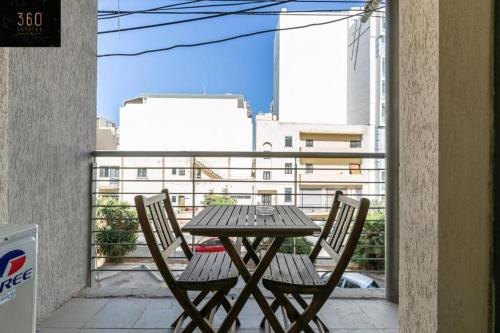 d'une table en bois et de deux chaises sur un balcon. dans l'établissement Cozy 1 Bedroom Oasis in the Heart of St. Julians by 360 Estates, à San Ġiljan
