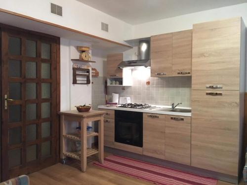 uma cozinha com armários de madeira e um forno com placa de fogão em Residence Fonte Eremita em Roccaraso