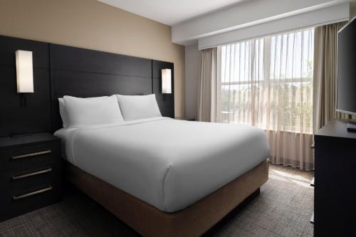 Residence Inn by Marriott Stockton في ستوكتون: سرير أبيض كبير في غرفة مع نافذة