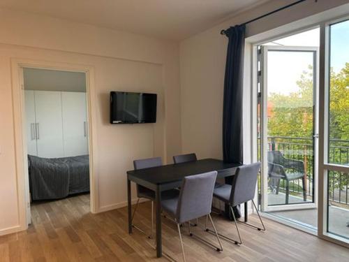 een eetkamer met een tafel en stoelen en een balkon bij City Apartment Dæmningen Vejle in Vejle