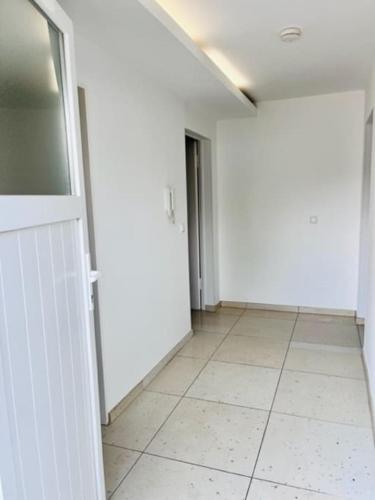 un pasillo vacío con paredes blancas y suelo de baldosa en Gemütliches 1-Zimmer Appartement, en Langen