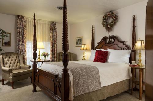 una camera con un grande letto e una sedia di The Roosevelt Inn a Coeur d'Alene
