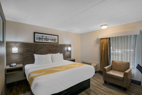 a hotel room with a large bed and a chair at Quality Inn Westfield - Springfield in Westfield