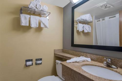ein Badezimmer mit einem Waschbecken, einem WC und einem Spiegel in der Unterkunft Quality Inn Westfield - Springfield in Westfield
