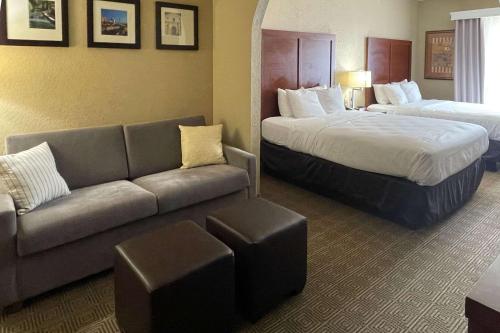 a hotel room with two beds and a couch at Comfort Suites Near Seaworld in San Antonio