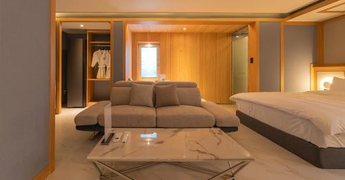 a living room with a couch and a bed at Hwangridan Stay in Gyeongju