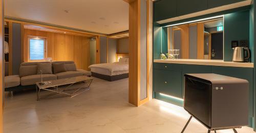 a living room with a couch and a bed in a room at Hwangridan Stay in Gyeongju