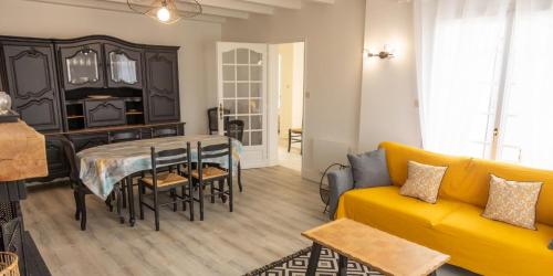 Villa Ernie في سان مارتن دو ري: غرفة معيشة مع أريكة صفراء وطاولة