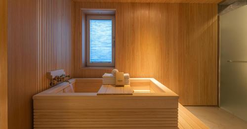 a bathroom with a bath tub with a window at Hwangridan Stay in Gyeongju