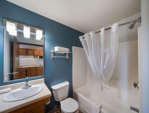 ein Badezimmer mit einem Waschbecken, einem WC und einem Spiegel in der Unterkunft WoodSpring Suites Fort Worth Trophy Club in Trophy Club