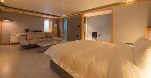 a bedroom with a large bed and a couch at Hwangridan Stay in Gyeongju