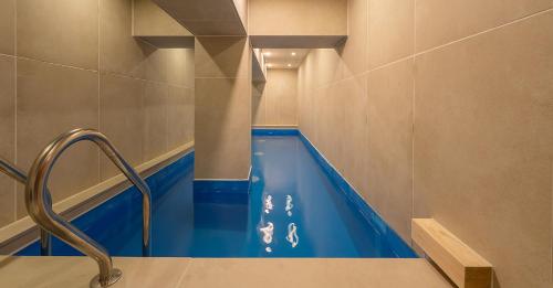 a bathroom with a tub with blue water in it at Hwangridan Stay in Gyeongju