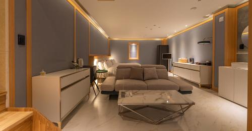 a living room with a couch and a table at Hwangridan Stay in Gyeongju