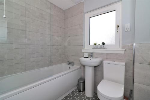 a white bathroom with a toilet and a sink at Signature - Moore View in Hamilton