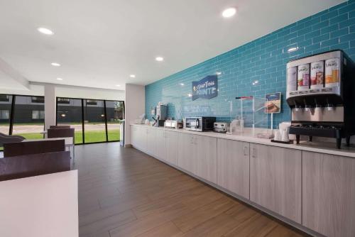 a coffee shop with a counter and a blue wall at Clarion Pointe OKC Airport in Oklahoma City