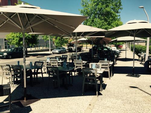 a group of tables and chairs under umbrellas at Nota Bene in Montceau-les-Mines