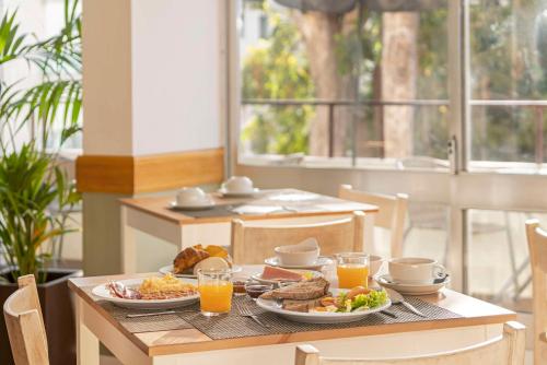 a table with plates of food and glasses of orange juice at Florasol Residence Hotel - Dorisol hotels in Funchal