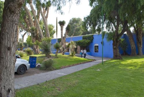 a blue building with people walking in front of it at Villas Arqueologicas Teotihuacan in San Juan Teotihuacán