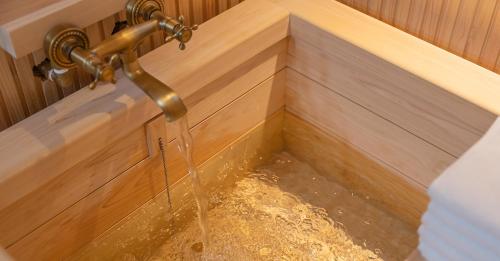 a shower with water coming out of a tap at Hwangridan Stay in Gyeongju