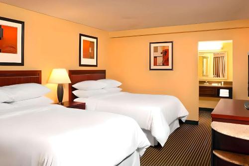 a hotel room with two beds and a desk at Quality Inn West Lafayette - University Area in Lafayette
