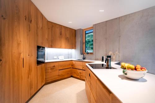 a kitchen with wooden cabinets and a bowl of fruit on a counter at Haus Moosberg - Erholung bei Seeblick und Ruhe in Gmunden
