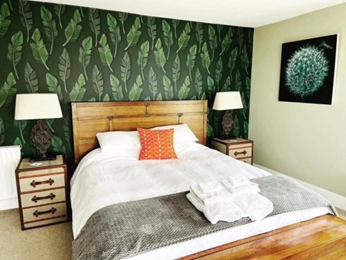 a bedroom with a bed and two nightstands with two lamps at Baie Mooar House, Boutique B&B in Ramsey